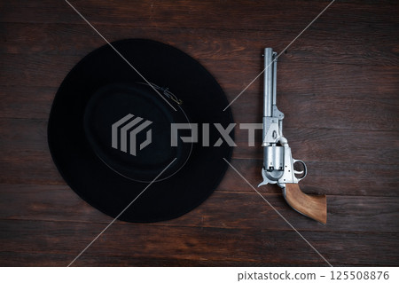 Old west gun and hat on table. Top view. Old west gun and hat on table. Top view. 125508876