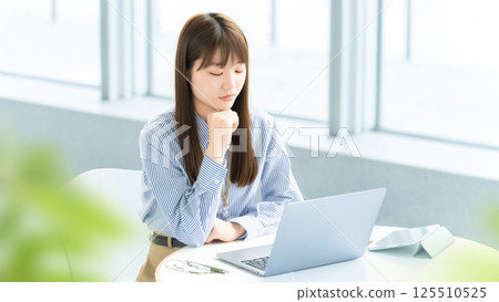 A woman/businesswoman thinking while looking at a computer screen 125510525