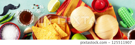 Cinco de Mayo Festive Setup with Nachos, Tequila, and Maracas Cinco de Mayo Festive Setup with Nachos, Tequila, and Maracas 125511907
