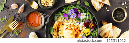 Gourmet Hummus with Edible Flowers and Spices on Dark Background 125511912