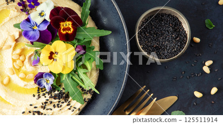 Gourmet Hummus with Edible Flowers, Black Sesame, and Pine Nuts 125511914