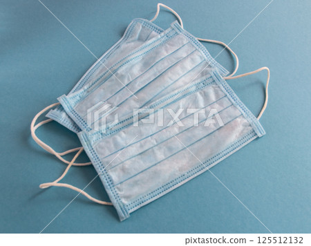 Medical mask for face on the blue background. Against pollution or virus protection. Coronavirus infection in all world. Health care. 125512132