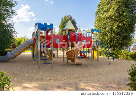 Colorful playground equipment inviting children to play on a sunny day Colorful playground equipment inviting children to play on a sunny day 125512329