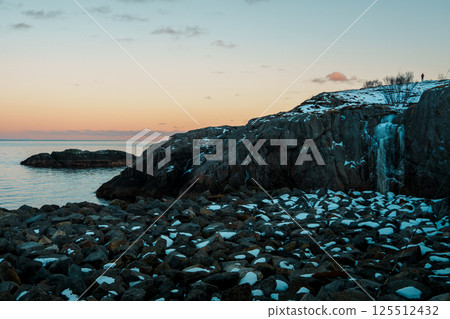 Serene Coastal Sunset with Rocky Shore at Lofoten Island 125512432