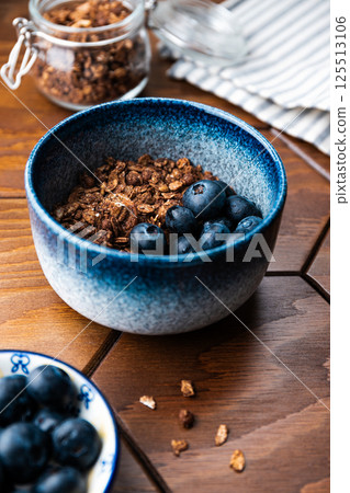Granola with chocolate, nuts and fresh blueberries. Healthy and simple breakfast. Granola with chocolate, nuts and fresh blueberries. Healthy and simple breakfast. 125513106