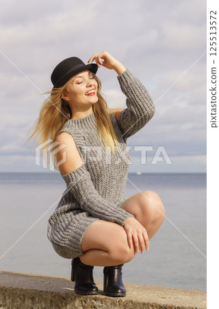 Woman wearing fedora and jumper outdoor 125513572