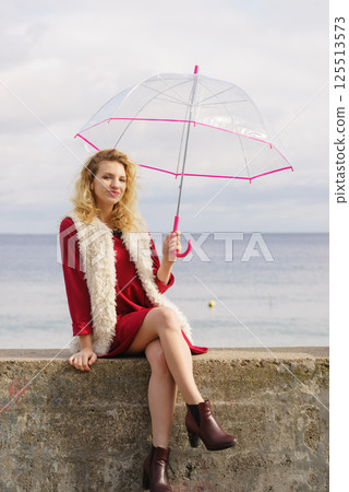 Happy woman holding umbrella Happy woman holding umbrella 125513573