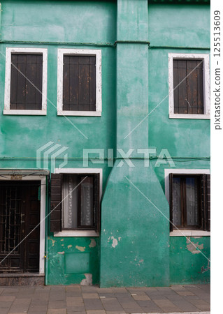 Old green house with dark shutters in Burano Italy 125513609