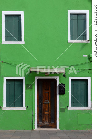 Bright green house with closed shutters in Burano Italy 125513610