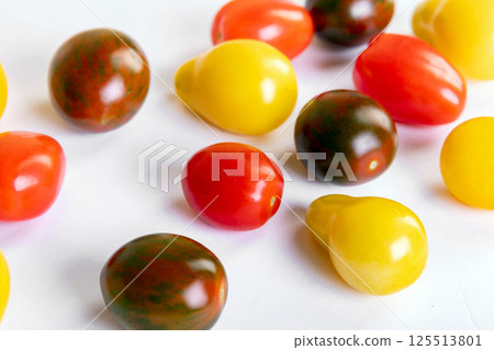 Assorted colorful cherry tomatoes crop on the white background. Assorted colorful cherry tomatoes crop on the white background. 125513801