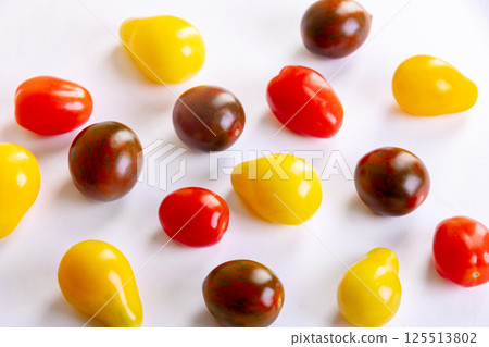 Assorted colorful cherry tomatoes crop on the white background. Assorted colorful cherry tomatoes crop on the white background. 125513802