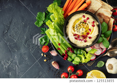 Fresh Hummus Platter with Vegetables and Pita on Dark Background Fresh Hummus Platter with Vegetables and Pita on Dark Background 125513855