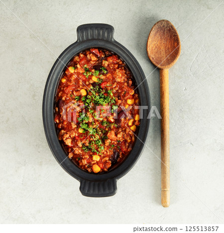 Mexican Chili with Corn Chips and Wooden Spoon on Light Background 125513857