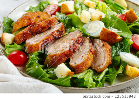 Caesar salad, with duck breast, on a light plate, on a light background, homemade, no people, 125513948
