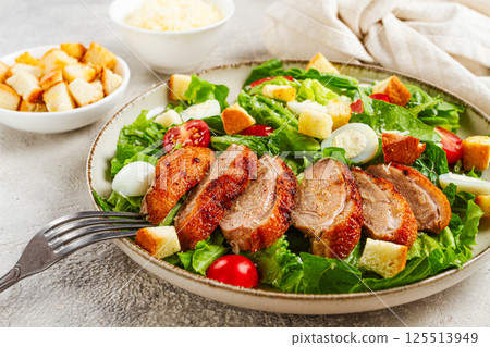 Caesar salad, with duck breast, on a light plate, on a light background, homemade, no people, 125513949