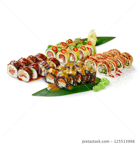 Variety of sushi rolls displayed on banana leaves with sesame seeds and spices Variety of sushi rolls displayed on banana leaves with sesame seeds and spices 125513998