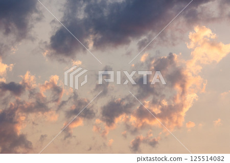 cumulus clouds on the sky blown by the wind. fluffy cloudscape. cloudy weather meteorology background in orange glow. evening mood 125514082