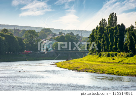 embankment of the river uzh in morning light. wonderful urban landscape in summer. linden alley on the left shore. scenic view of uzhhorod downtown 125514091