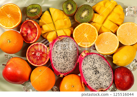 Fresh dragon fruit, pitahaya, mango, blood orange, lemons, kiwi and oranges close-up. Summer exotic tropical fruits, banner for a cafe or store, postcard for advertising an Asian market 125516044