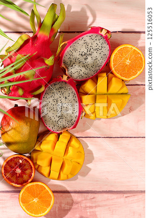 Summer banner with tropical exotic fruits, Dragon fruit, pitaya, mango and oranges on a sunny table. Template for design. Healthy vegan food for weight loss, Advertising card for a store 125516053