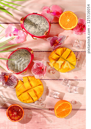 Summer banner with tropical exotic fruits, Dragon fruit, pitaya, mango and oranges on a sunny table. Template for design. Healthy vegan food for weight loss, Advertising card for a store 125516054