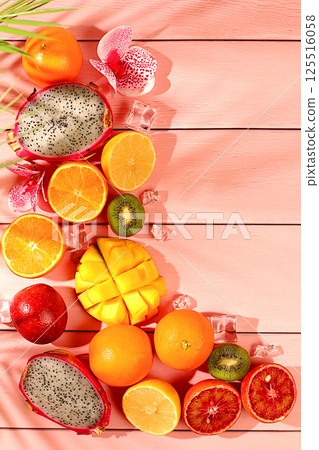 Dragon fruit, pitaya, mango, kiwi, avocado, apples, citrus and oranges on sunny table. Summer banner with tropical exotic fruits and juice with space for text. Healthy vegan food for weight loss 125516058