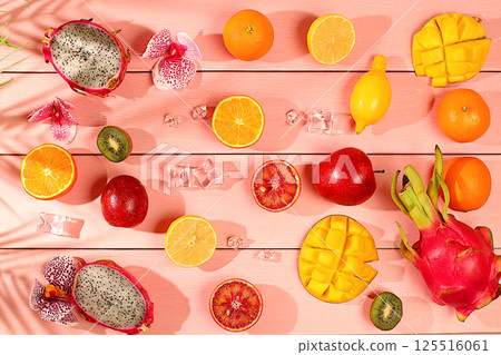 Dragon fruit, pitaya, mango, kiwi, avocado, apples, citrus and oranges on sunny table. Summer banner with tropical exotic fruits. Healthy vegan food for weight loss, advertising postcard. 125516061