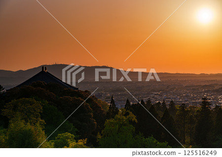 東大寺二月堂的日落天空。太陽落在生駒山脈上，天空和寺廟地面被染成金色。 125516249