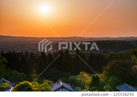 東大寺二月堂的日落天空。太陽落在生駒山脈上，天空和寺廟地面被染成金色。 125516250