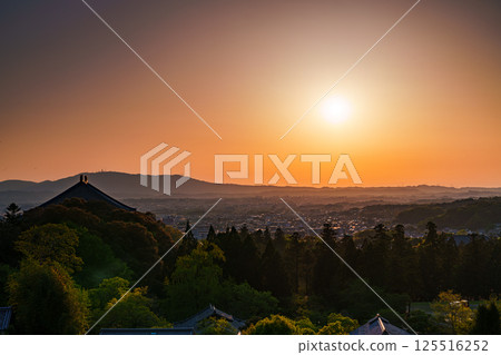 東大寺二月堂的日落天空。太陽落在生駒山脈上，天空和寺廟地面被染成金色。 125516252