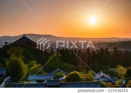 東大寺二月堂的日落天空。太陽落在生駒山脈上，天空和寺廟地面被染成金色。 125516253