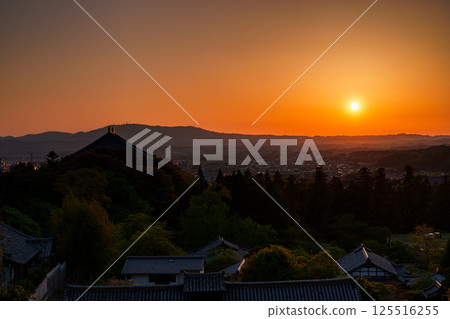 東大寺二月堂的日落天空。太陽落在生駒山脈上，天空和寺廟地面被染成金色。 125516255