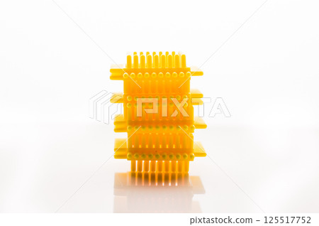 The children's construction set in yellow tones evokes associations with sunshine and warmth. The play pieces are set against a white background. 125517752