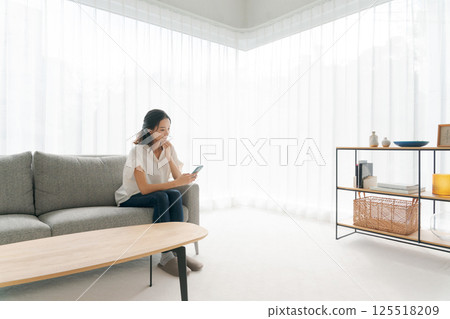 一個女人坐在沙發上和放鬆 125518209