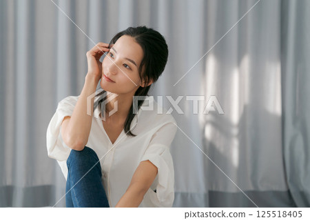 A woman sitting on the window side A woman sitting on the window side 125518405