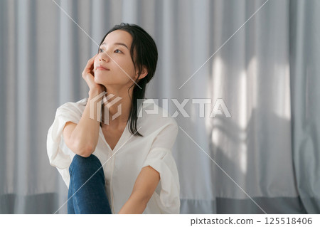 A woman sitting on the window side A woman sitting on the window side 125518406