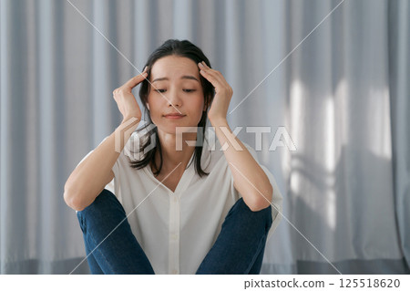 Depressed woman sitting by the window 125518620