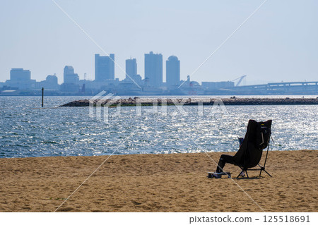 Early summer sea: A person reading a book relaxing in a chair at Shioashiya Beach in Ashiya City 125518691