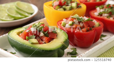 Sliced Bell Peppers as Scoops A vivid closeup of fresh bell pepper halves filled with avocado and salsa demonstrating a crunchy alternative for dips or fillings instead of. 125518740