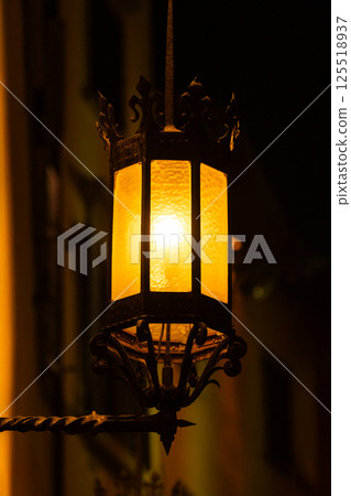 Vintage street lantern illuminated at night creating warm atmosphere 125518937