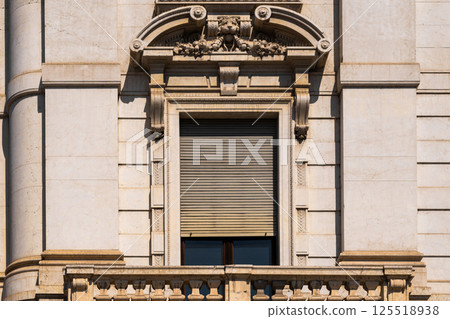 Elegant architectural facade featuring ornate stonework and classic window design 125518938