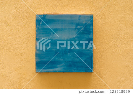 Abstract blue painting on yellow textured wall, minimalist art for modern home decor 125518939