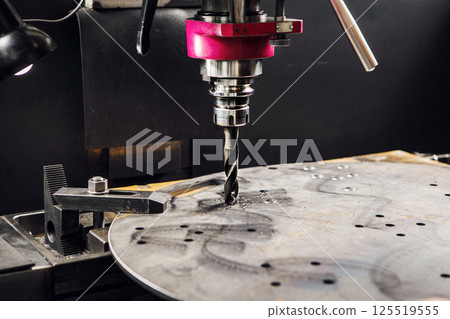 Vertical drill makes holes in metal part. Close-up of metal drilling machine.  125519555