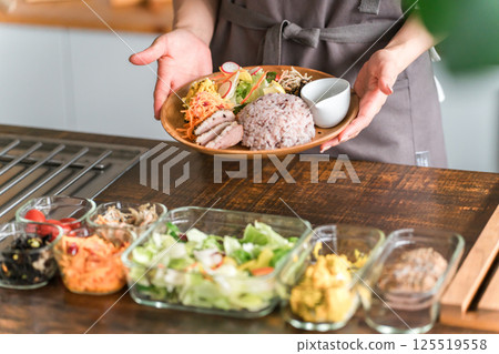 A housewife serving a one-plate lunch in the kitchen 125519558