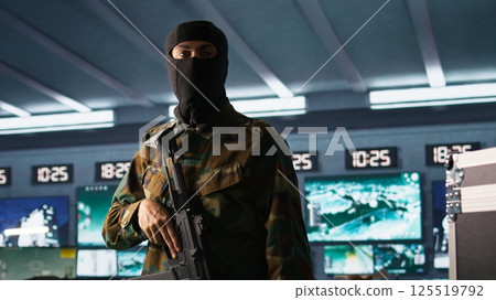 Terrorist occupying enemy base of operations, conducting guerilla warfare. Rebel forces hijacker with firearm in hidden war room starting offensive against opponents, camera B Terrorist occupying enemy base of operations, conducting guerilla warfare. Rebel forces hijacker with firearm in hidden war room starting offensive against opponents, camera B 125519792