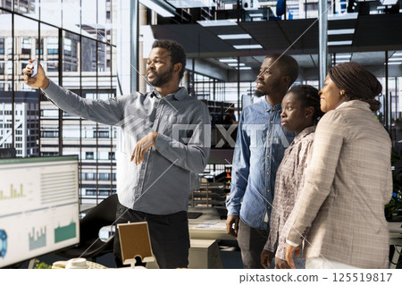 Smiling african american team taking photos at the corporate office, having fun and laughing around on webcam. Business coworkers making memories and enjoying a break, collaboration. Smiling african american team taking photos at the corporate office, having fun and laughing around on webcam. Business coworkers making memories and enjoying a break, collaboration. 125519817