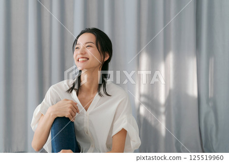 窗簾前微笑的女人 125519960