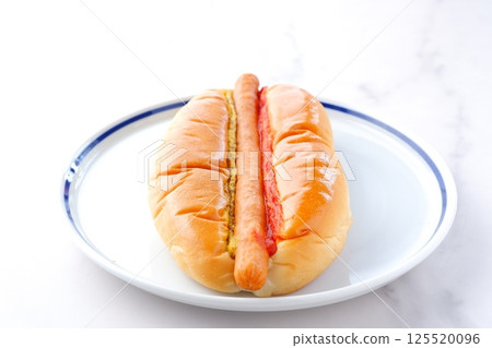 Chorizo sausage bun (hot dog) with mustard and ketchup 125520096