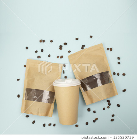 Eco-friendly paper bags containing ground coffee and whole beans on blue backdrop, flat lay, top view Eco-friendly paper bags containing ground coffee and whole beans on blue backdrop, flat lay, top view 125520739