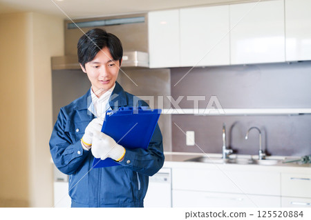 A male worker inspecting an apartment building with a sincere attitude 125520884